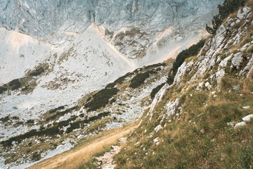 Hiking trail high in the mountains with lots of rocks and dry grass in the autumn, Durmitor, Montenegro