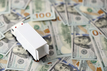 Delivery truck on hundred dollar bills banknotes. Background of moving or trucking concept close up