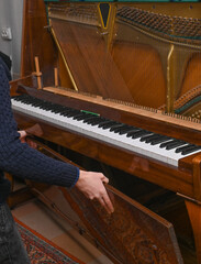 a man disassembles an old piano for repair