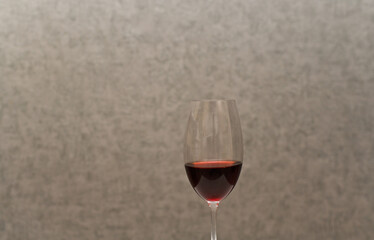 red wine in a glass. on a gray background
