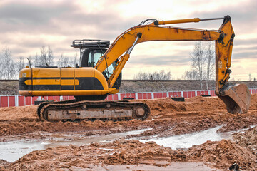 Excavator on earthworks at construction site. Backhoe on foundation work and road construction....