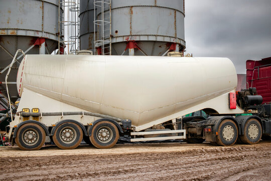 Large truck for transporting cement. A cement truck unloads cement at a concrete plant. Concrete production.