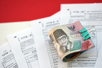 Indonesian tax forms 1770 Individual Income Tax Return and money on table close up