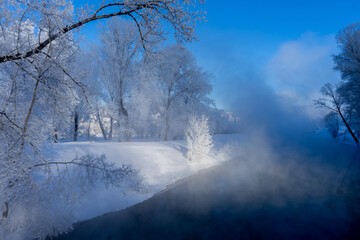 Winter landscape with a river and trees in hoarfrost on a sunny day