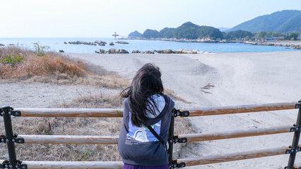 海に思いを馳せる女性の後ろ姿