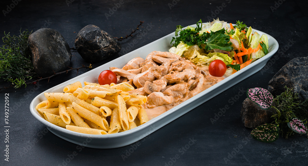 Sticker penne pasta with chicken, mushrooms, onions, cream sauce and fresh vegetable salad of carrots, lettu