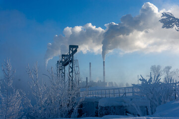 Industrial landscape with smokestack in winter and blue sky