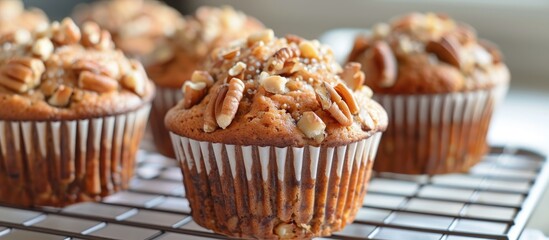 A detailed view of a freshly baked homemade banana nut muffin cooling on a wire rack after being taken out of the oven. The muffin is topped with chopped nuts and has a golden-brown crust.