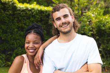 Obraz premium Diverse couple, a young African American woman and young Caucasian man, are smiling outdoors