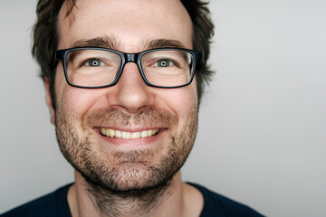 Obraz premium Joyful Executive: Handsome Man Wearing Glasses Smiles against Clean Background