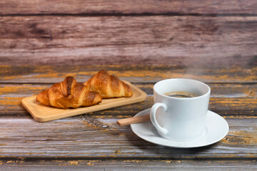 湯気の上がる温かいコーヒーとクロワッサン