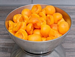 Selected apricots are halved and pips removed and prepared for weighing
