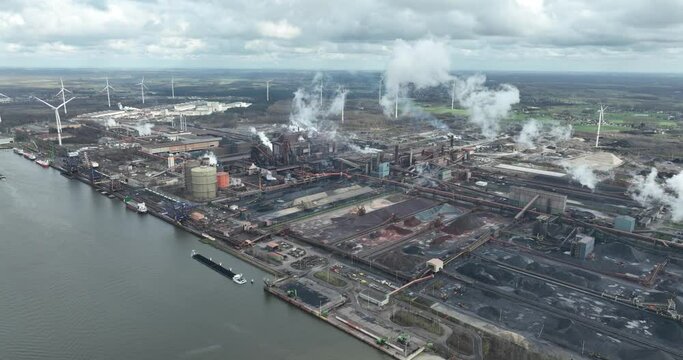 Aerial drone view of a large scale blast furnace, industrial area creating metal. Smoking smoke stacks in Ghent, Belgium.