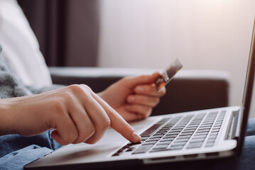 Business concept. Female hand holding credit card and using laptop. Businesswoman or entrepreneur...