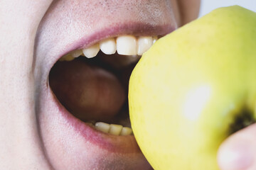 Man is eating green apple. Healthy lifestyle, healthy food. Vitamins for white healthy teeth.