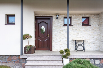 Designer entrance door to a country house. Modern design. luxurious exterior. Facade of a modern building with modern doors