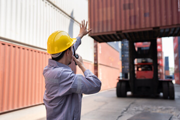 Asia logistic engineer man worker or foreman working direct driver forklift container at container...
