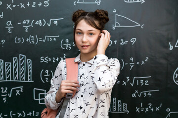 Teenage Girl with School Bag Standing the Blackboard. Portrait of a schoolgirl 10 - 12 years old.