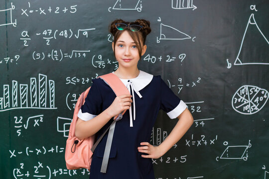 Teenage Girl with School Bag Standing Blackboard. Portrait of a schoolgirl 10 - 12 years old.