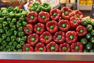 Green and red pepper displayed on a market counter