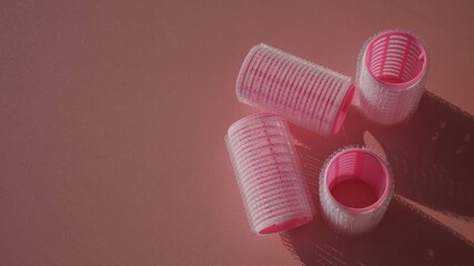 pink curlers on a pink background. hairdressing tools - Powered by Adobe
