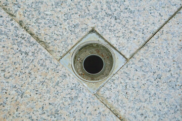 an iron drain hole in the ceramic floor  