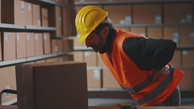 Tired warehouse worker having back pain