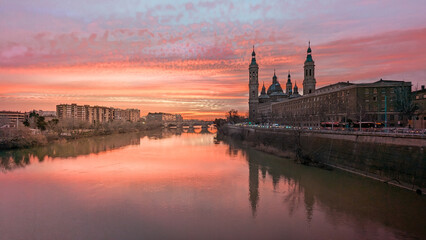 Fototapeta premium Painting the Firmament: Zaragoza Shines in Warm Tones in a Unique Sunset in Front of the Pilar and the Ebro River