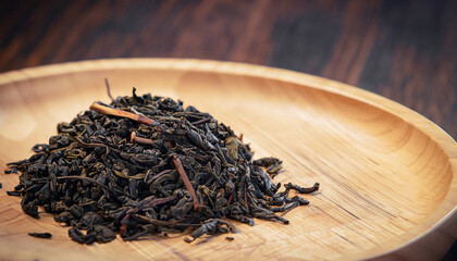 Fototapeta premium close-up of dry Chinese tea in wooden bowl, vintage tone, selective focus