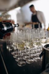 The waiter fills the glass with champagne. Catering, welcome drink, service, alcohol. A solemn event