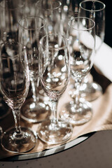 Many empty champagne or wine glasses sparkle in the sun. Preparation for a reception or holiday, a container for alcoholic beverages. Restaurant, catering, service