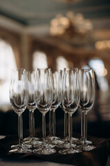 Many empty champagne or wine glasses sparkle in the sun. Preparation for a reception or holiday, a container for alcoholic beverages. Restaurant, catering, service