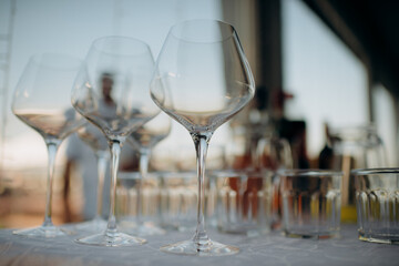 Many empty champagne or wine glasses sparkle in the sun. Preparation for a reception or holiday, a container for alcoholic beverages. Restaurant, catering, service