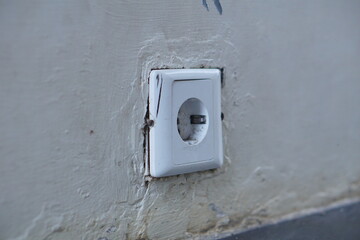 a white plastic electrical plug on the bottom wall  