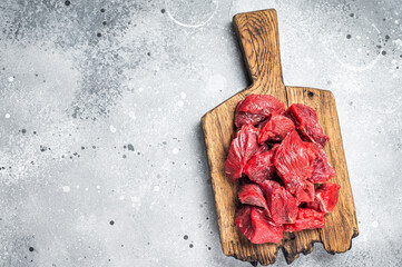 Raw organic diced lamb meat for cooking Goulash. Gray background. Top view. Copy space