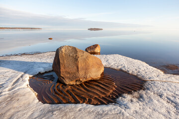 Tranquil spring evening by the calm sea on a sandy beach with still some ice left, Bothnian Bay,...