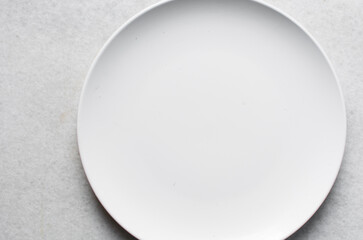 Top view of white ceramic plates on a marble table, white ceramic minimalist white plate