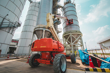 Male industry working at high in a boom liftinspection tank silo © chitsanupong