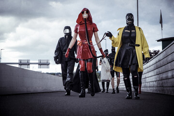 A group of people in Latex and Rubber walking fully masked in public