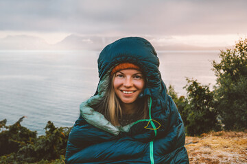 Woman hiker in sleeping bag camping gear morning in mountains active travel vacations outdoor, traveler girl portrait in Norway active adventure eco tourism healthy lifestyle hobby - 749358617