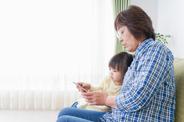 おばあちゃんとスマホを使う子供