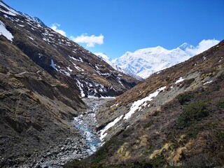 A breathtaking vista of majestic mountains flanking a meandering river, creating a harmony of nature's beauty.