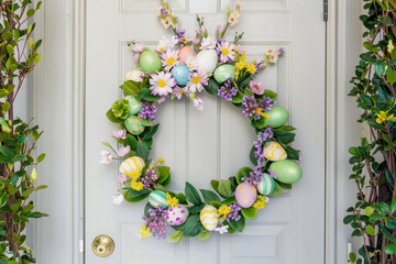 Spring Easter wreath of pastel eggs and flowers on the door of the house