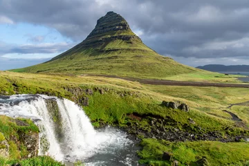 Photo sur Plexiglas Kirkjufell Low angle view of the Kirkjufell mountain near Grundarfjordur in Iceland with lower fall of Kirkjufell waterfall in foreground flowing into the sea in background