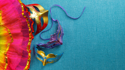 Beautiful white and multicolor carnival masks on a blue background. Purim, Mardi Gras. Top view