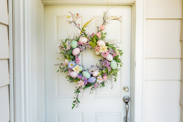 Spring Easter wreath of pastel eggs and flowers on the door of the house