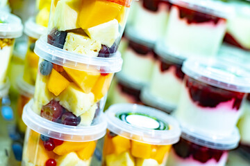 Pre-packaged fruit salads displayed in a commercial refrigerator