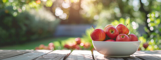 white bowl with red apples on nature background