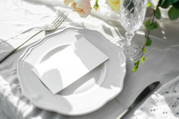 Romantic dining table setting with empty white card mockup on the plate, rose flower, cutlery, and...