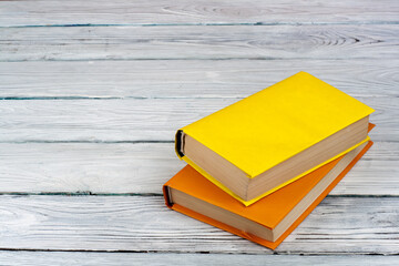 Multi-colored books on a white wooden table. Copy space for text.